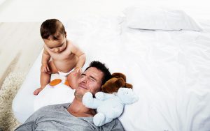 a father and a baby on the bed