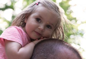 girl sitting on fathers head