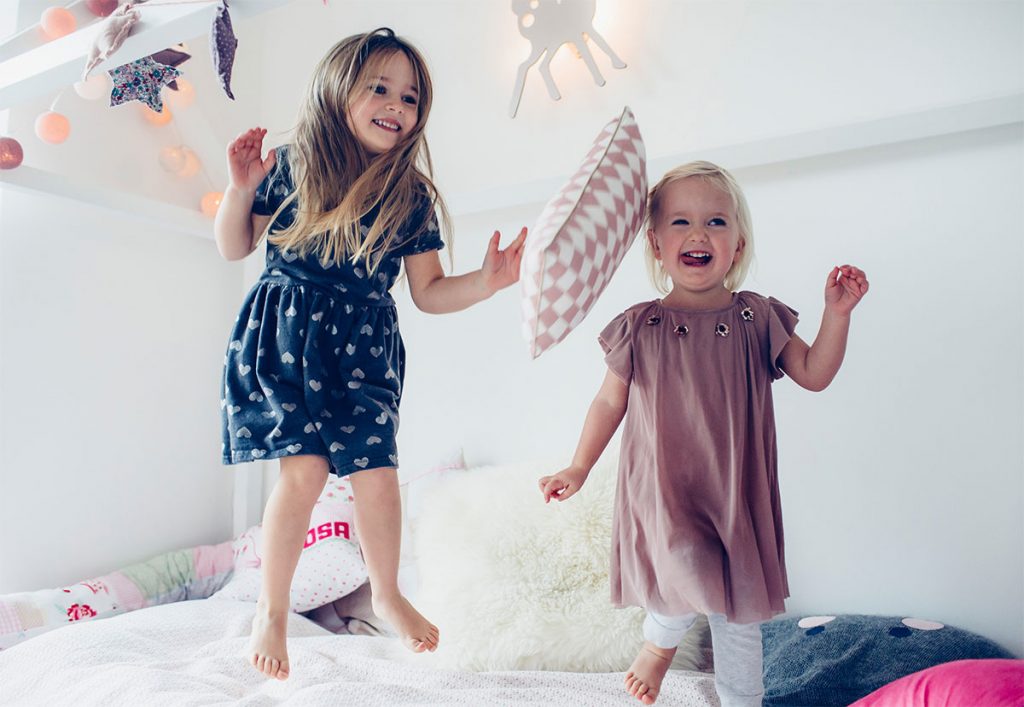 sisters jumping on the bed